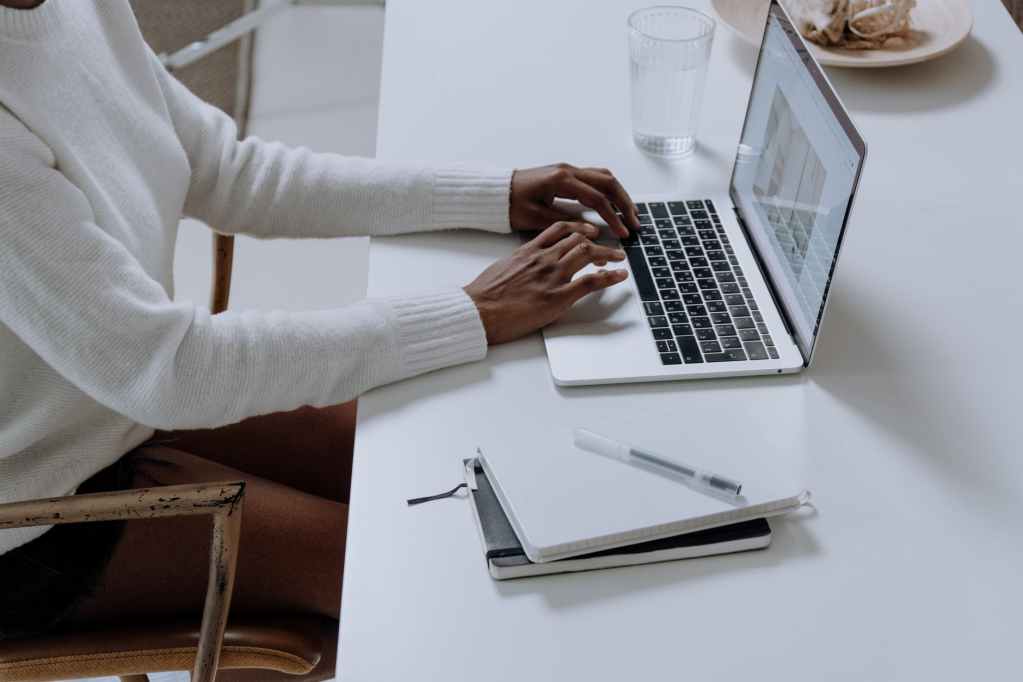 person in white long sleeve shirt using macbook pro